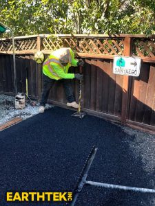 worker installing asphalt on a driveway