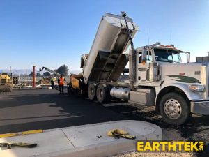 truck and paver working together to lay asphalt