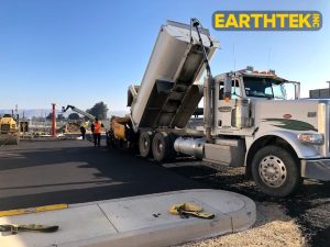 Asphalt paver and and dump truck working together
