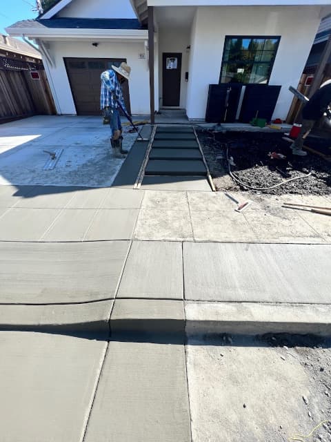 worker installing a concrete sidewalk